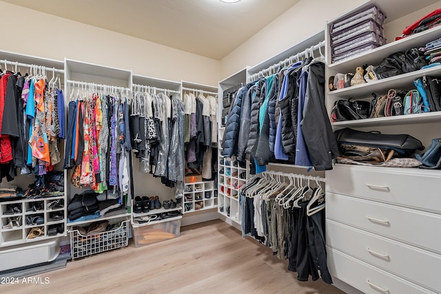 walk in closet with light hardwood / wood-style floors