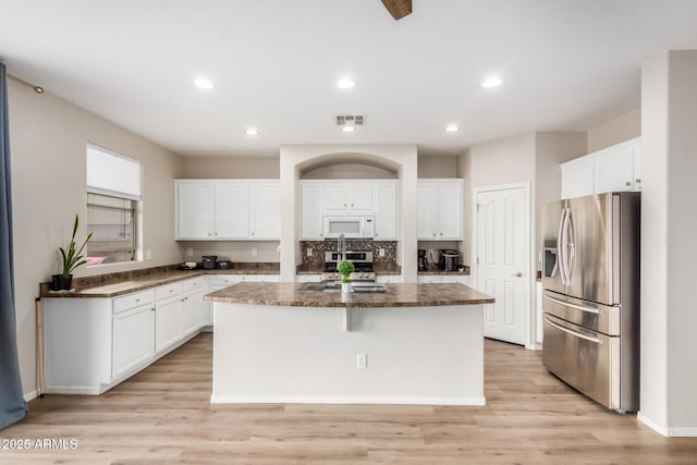 kitchen featuring a center island, white cabinets, and stainless steel appliances