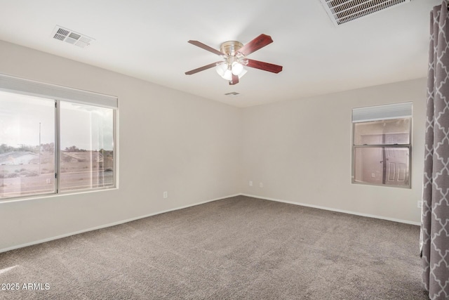 carpeted empty room featuring visible vents, baseboards, and a ceiling fan