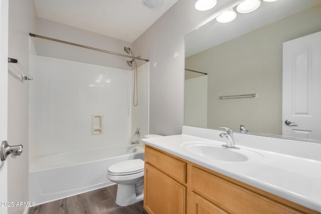 bathroom featuring toilet, wood finished floors, vanity, and shower / tub combination