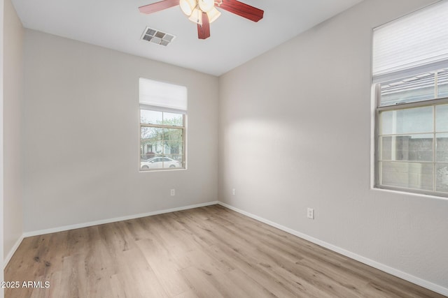 spare room with visible vents, baseboards, wood finished floors, and a ceiling fan