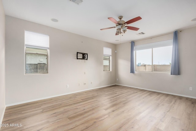 empty room with ceiling fan, baseboards, visible vents, and light wood-type flooring