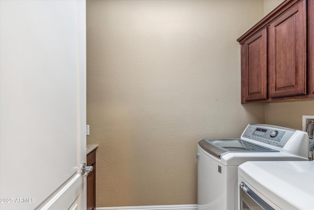 washroom with cabinet space and washer and dryer