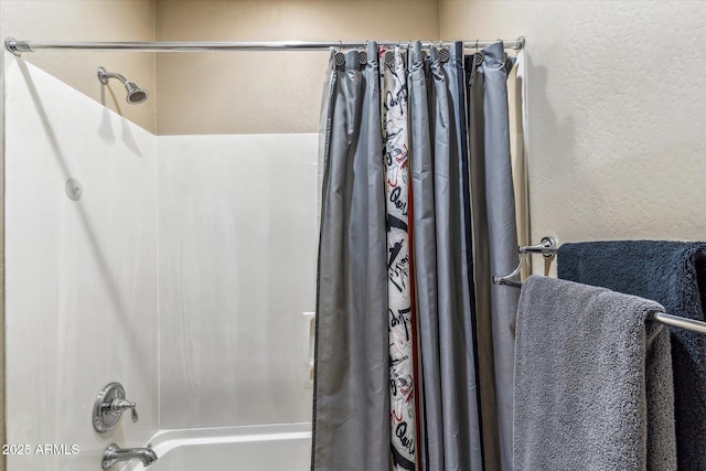 full bath with a textured wall and shower / bath combination with curtain