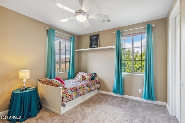 carpeted bedroom with baseboards, visible vents, and ceiling fan