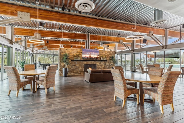 dining room featuring a wall of windows, wood finish floors, visible vents, and a fireplace