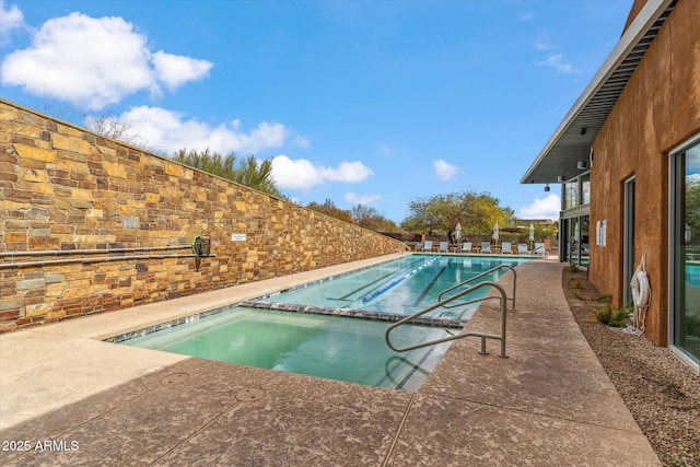 community pool featuring a patio area and a hot tub