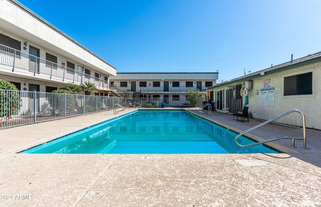 community pool with a patio and fence