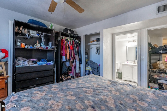bedroom featuring a ceiling fan, visible vents, and ensuite bathroom