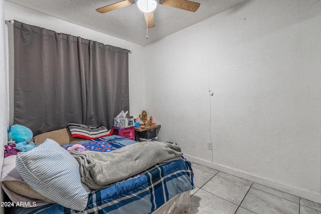 bedroom featuring a ceiling fan, baseboards, and tile patterned flooring