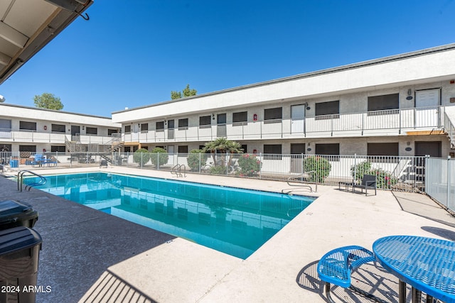 pool featuring fence and a patio area