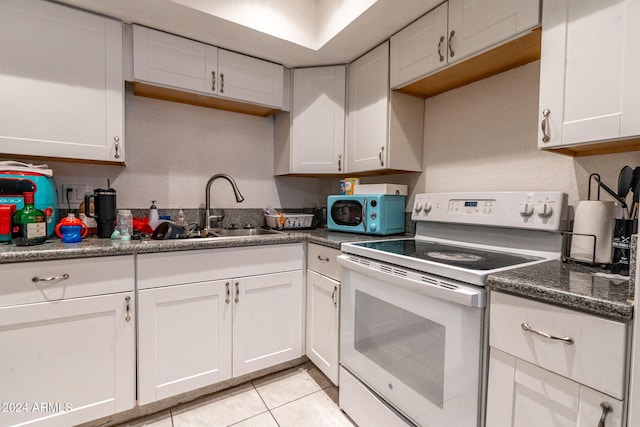 kitchen featuring a sink, electric range, light tile patterned flooring, and white cabinetry