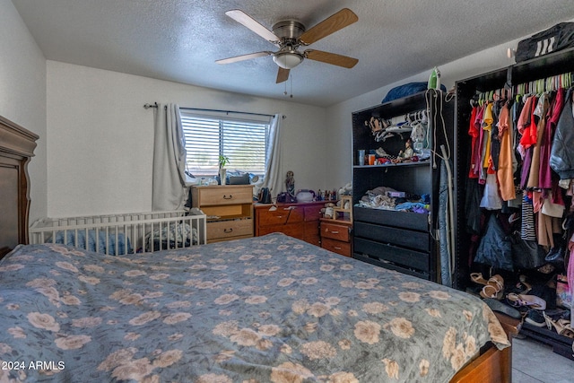 bedroom with ceiling fan and a textured ceiling