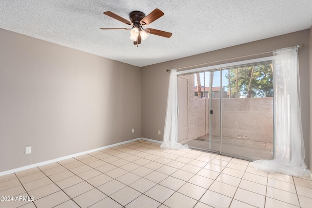 empty room featuring ceiling fan, a textured ceiling, and light tile patterned flooring