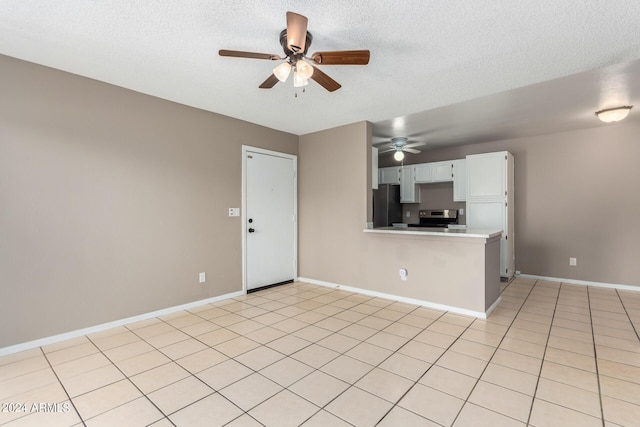 unfurnished living room with a textured ceiling, light tile patterned floors, and ceiling fan