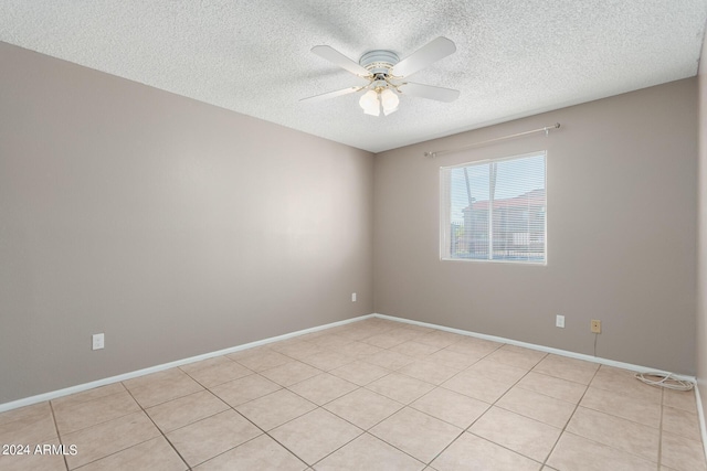 tiled spare room featuring a textured ceiling and ceiling fan