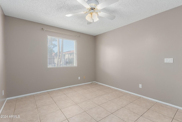 tiled spare room with ceiling fan and a textured ceiling