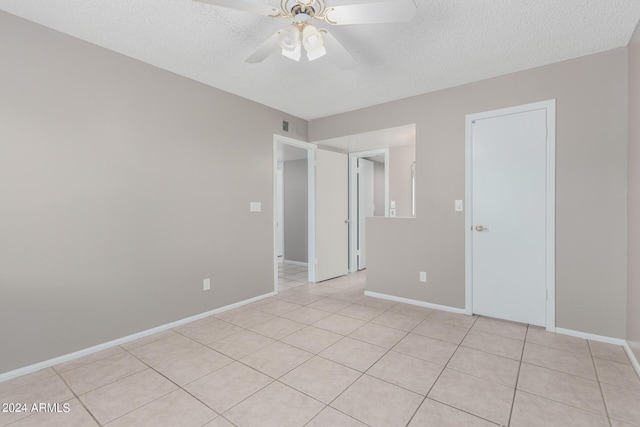 unfurnished room featuring light tile patterned flooring, a textured ceiling, and ceiling fan