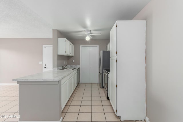 kitchen with white cabinets, light tile patterned floors, and stainless steel appliances