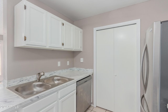 kitchen with sink, white cabinetry, stainless steel appliances, and light tile patterned flooring