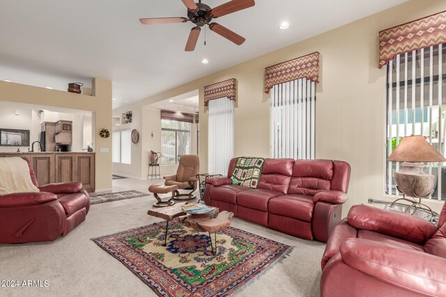 carpeted living room with ceiling fan