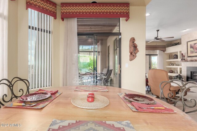 dining room featuring a tile fireplace and ceiling fan