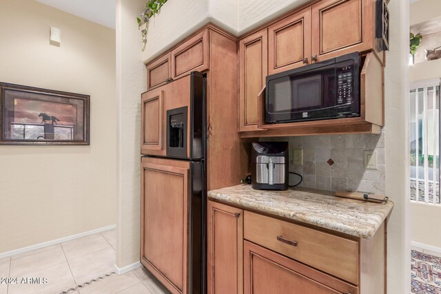 kitchen featuring decorative backsplash, paneled built in fridge, light stone counters, and light tile patterned flooring