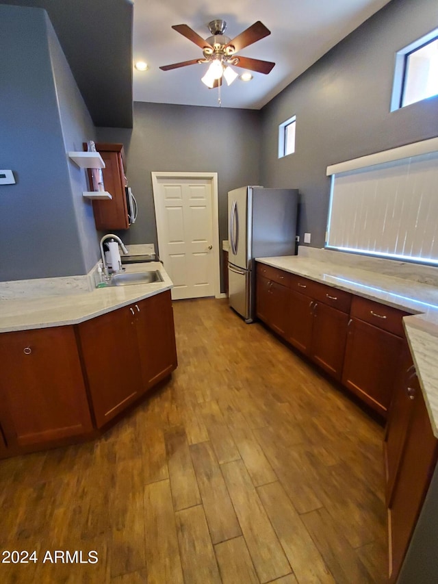 kitchen with light wood-type flooring, stainless steel appliances, ceiling fan, and sink