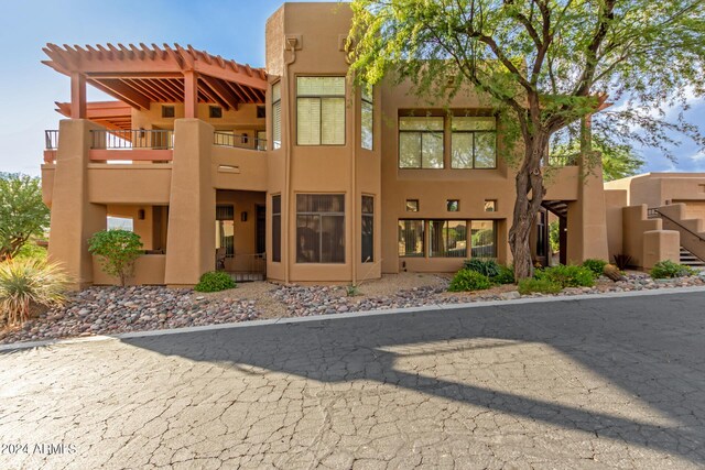 rear view of property featuring a pergola