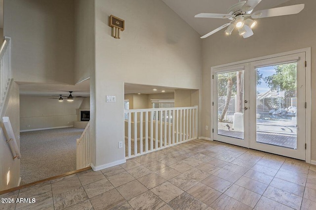 interior space featuring ceiling fan, high vaulted ceiling, french doors, and baseboards