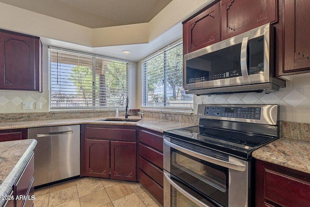 kitchen featuring stainless steel appliances, tasteful backsplash, a sink, and dark brown cabinets