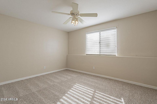 carpeted spare room with baseboards and a ceiling fan