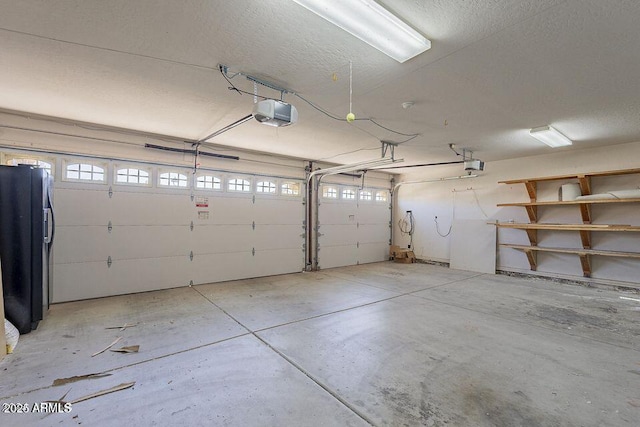 garage with black fridge and a garage door opener