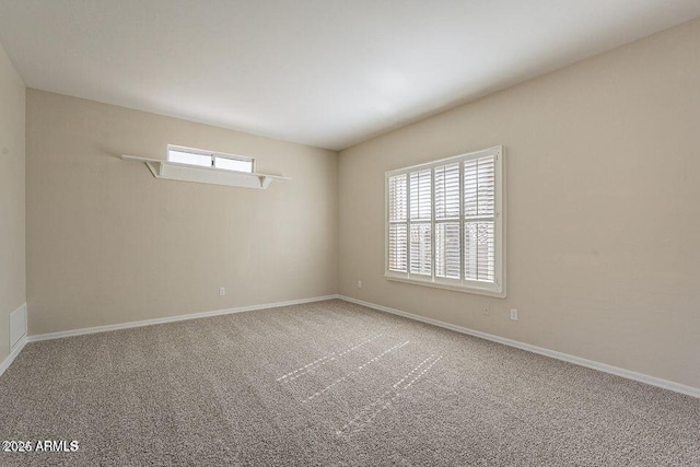 empty room featuring carpet and baseboards