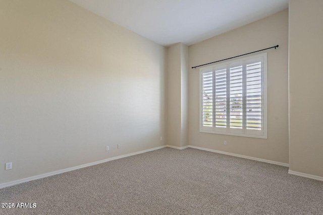 unfurnished room with carpet flooring and baseboards