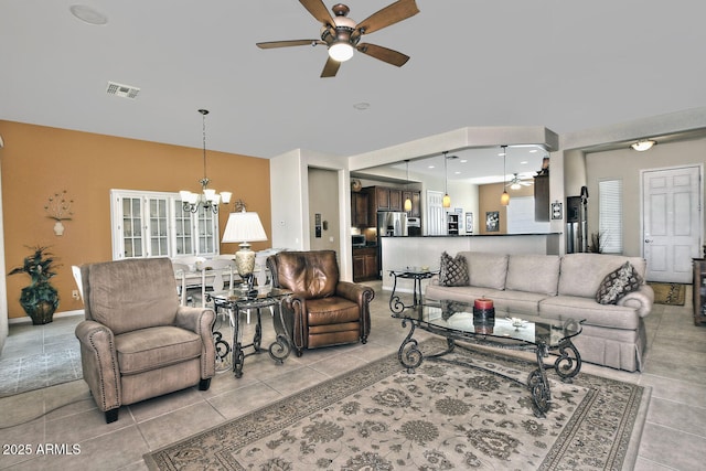 tiled living room with ceiling fan with notable chandelier