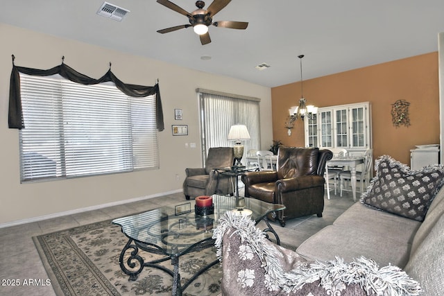 living room featuring light tile patterned floors and ceiling fan with notable chandelier