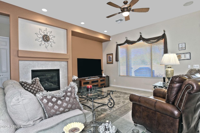 tiled living room featuring a tile fireplace and ceiling fan