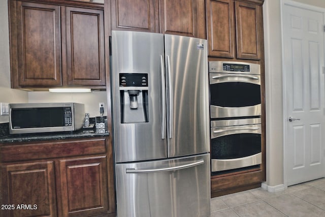 kitchen featuring dark brown cabinets, light tile patterned floors, and appliances with stainless steel finishes