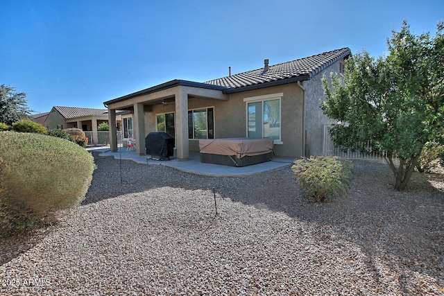 rear view of house featuring a patio area and a hot tub