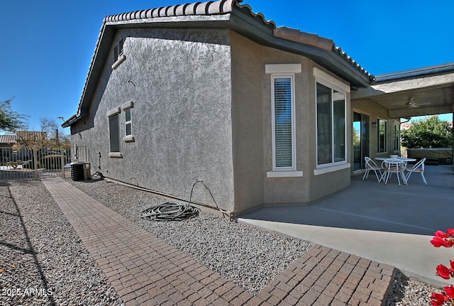 view of side of property featuring a patio area and central AC