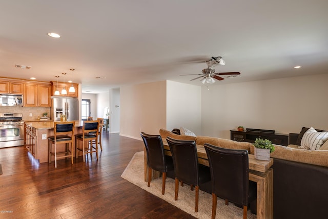 dining space with ceiling fan and dark hardwood / wood-style floors