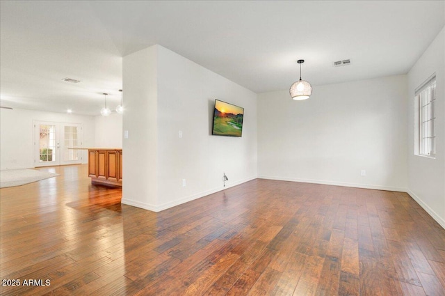 empty room featuring dark hardwood / wood-style flooring and a chandelier