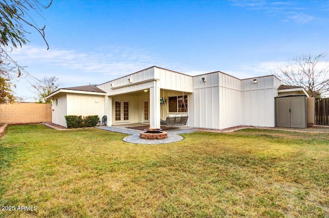 back of property featuring a storage unit, a yard, a patio, and french doors