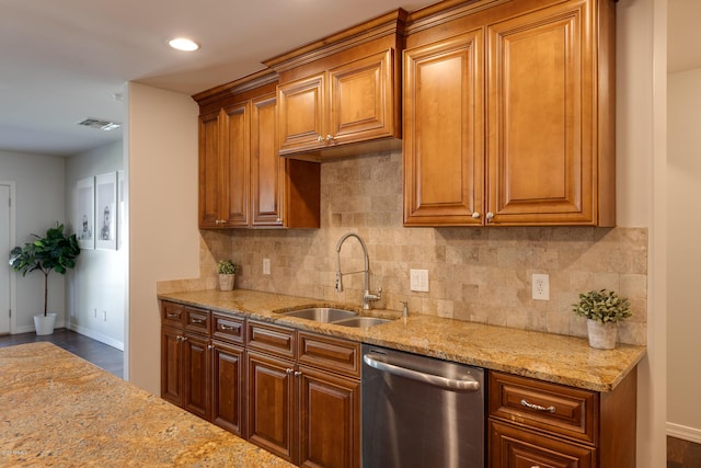 kitchen with tasteful backsplash, light stone countertops, dishwasher, and sink