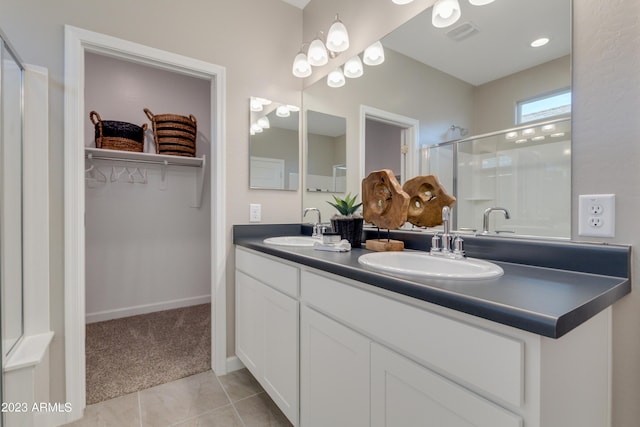 bathroom featuring tile patterned flooring, vanity, and walk in shower