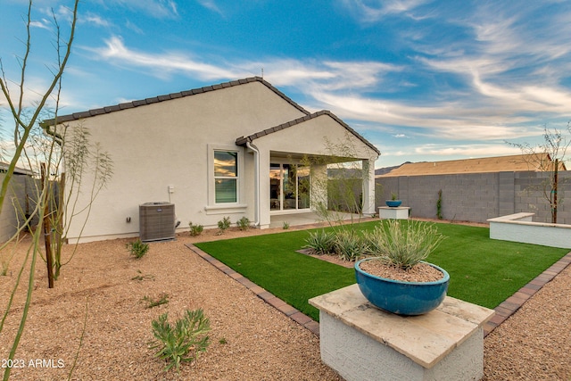 back of property featuring a yard, cooling unit, and a patio area