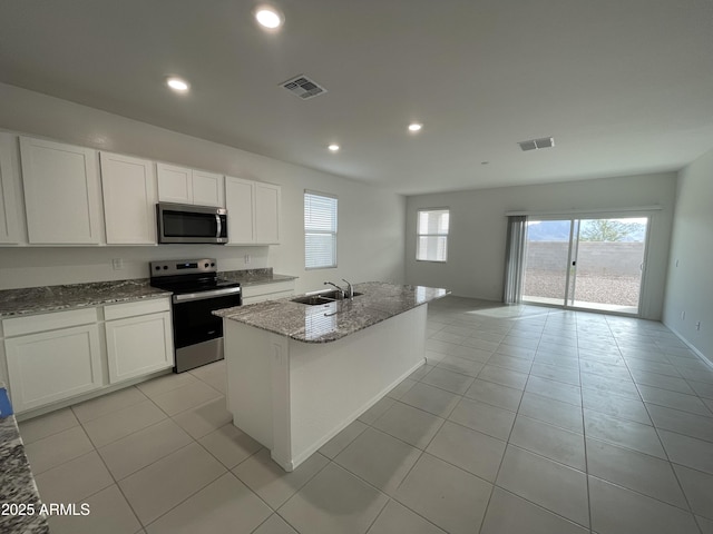 kitchen featuring white cabinetry, a kitchen island with sink, sink, and stainless steel appliances