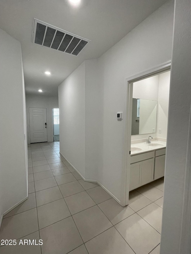 hallway featuring sink and light tile patterned floors