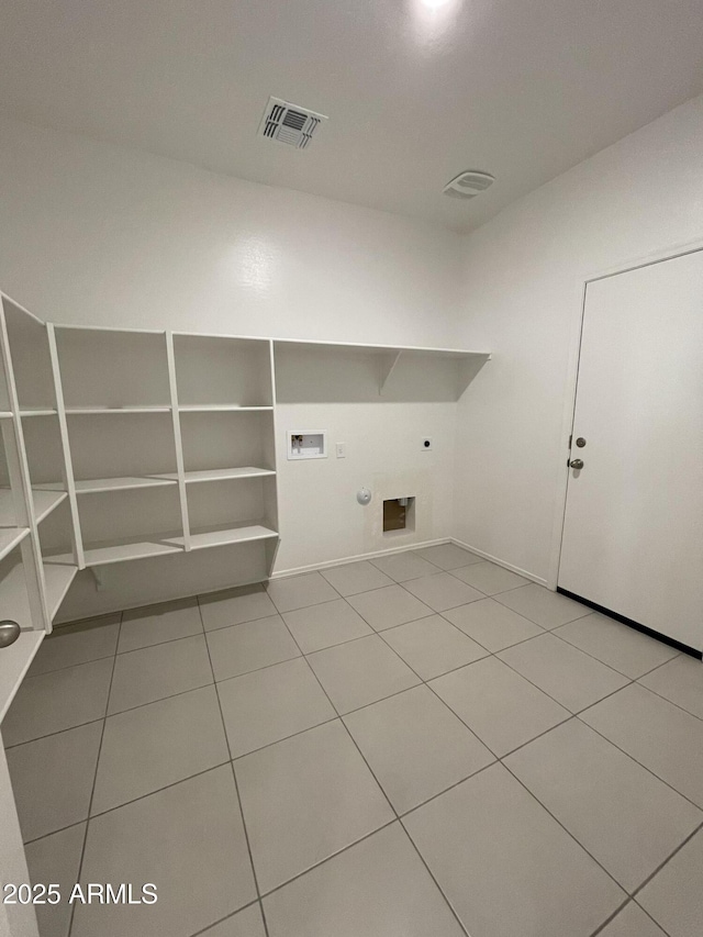 washroom featuring hookup for an electric dryer, hookup for a gas dryer, light tile patterned floors, and hookup for a washing machine